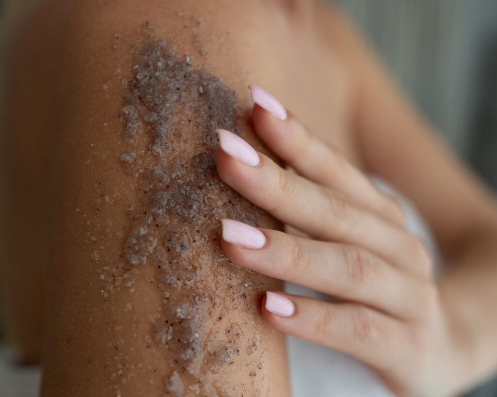 gently applying a body scrub or exfoliating product